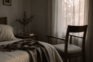 Habitación con una cama y una silla vacía al lado.